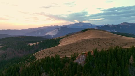 Beautiful-green-mountain-landscape-with-colorful-sunset-at-horizon-in-Romania,Europe---Aerial-drone-panoramic-shot