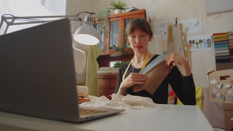 female dressmaker discussing fabric on video call