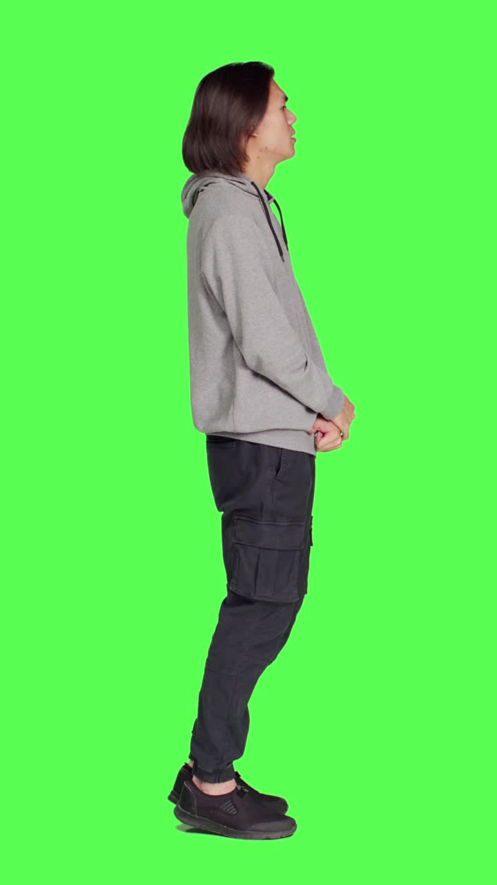 Profile of young guy poses against greenscreen