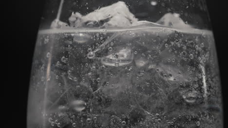 frozen blocks sparkling drink glass closeup. refreshing cocktail concept