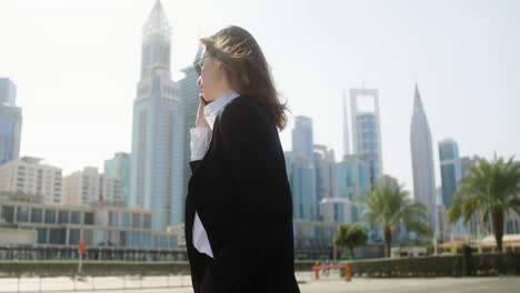 elegant businesswoman with phone outdoors