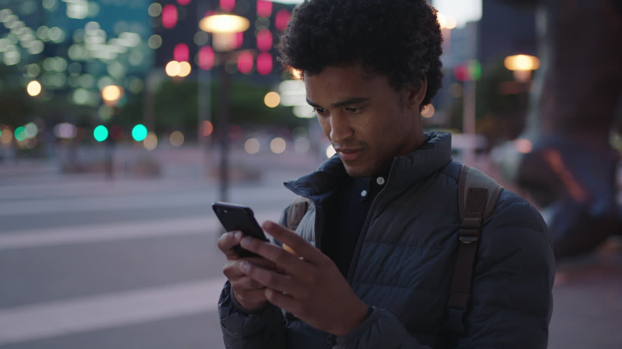 portrait of handsome mixed race man taking photo of city lights using smartphone camera technology enjoying urban evening