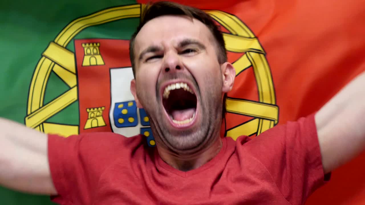 fanático portugués celebra sosteniendo la bandera de portugal en cámara lenta,4k, de alta calidad