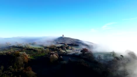 la niebla baja que rodea glastonbury tor