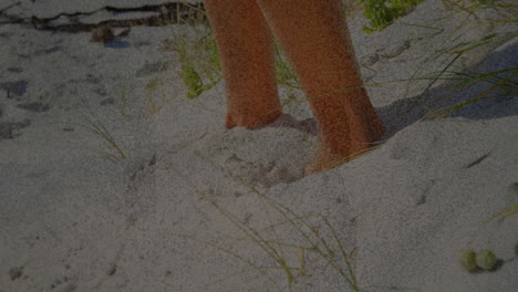 bare feet walking across bright white sand dunes showing sparse grass tufts in 3d render