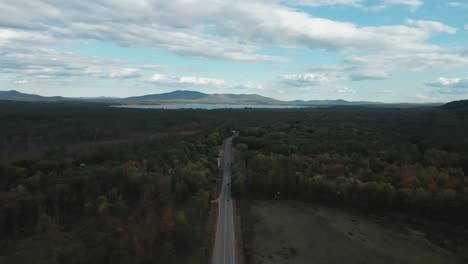 aerial high above new hampshire highway lowering slowly, cars driving away