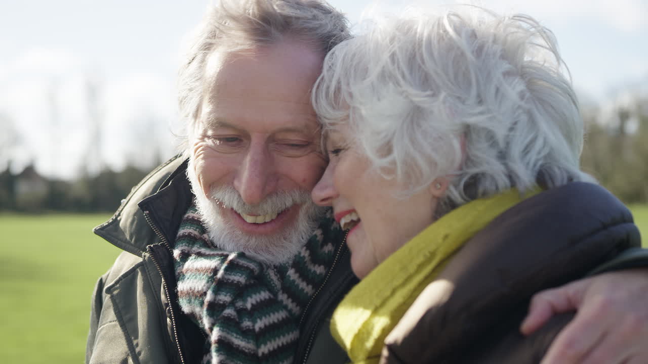 primer plano de una pareja de ancianos enamorados abrazados caminando juntos por el parque de otoño o invierno