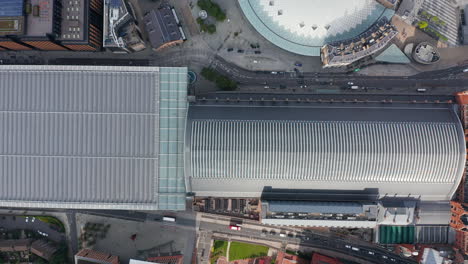 Aerial-birds-eye-overhead-top-down-panning-view-of-St-Pancras-train-station-large-roof.-Cars-driving-on-street-in-front-of-building.-London,-UK