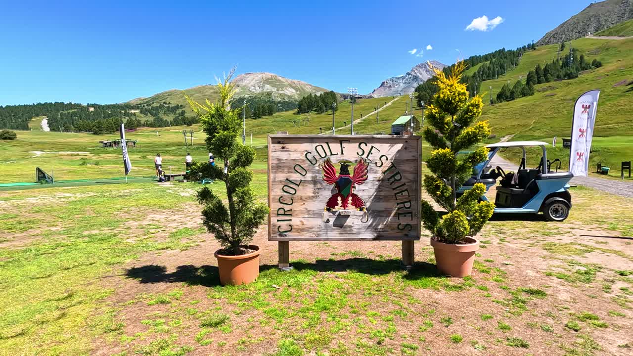 골프 카트가 입구 표지판을 지나가고 있습니다.