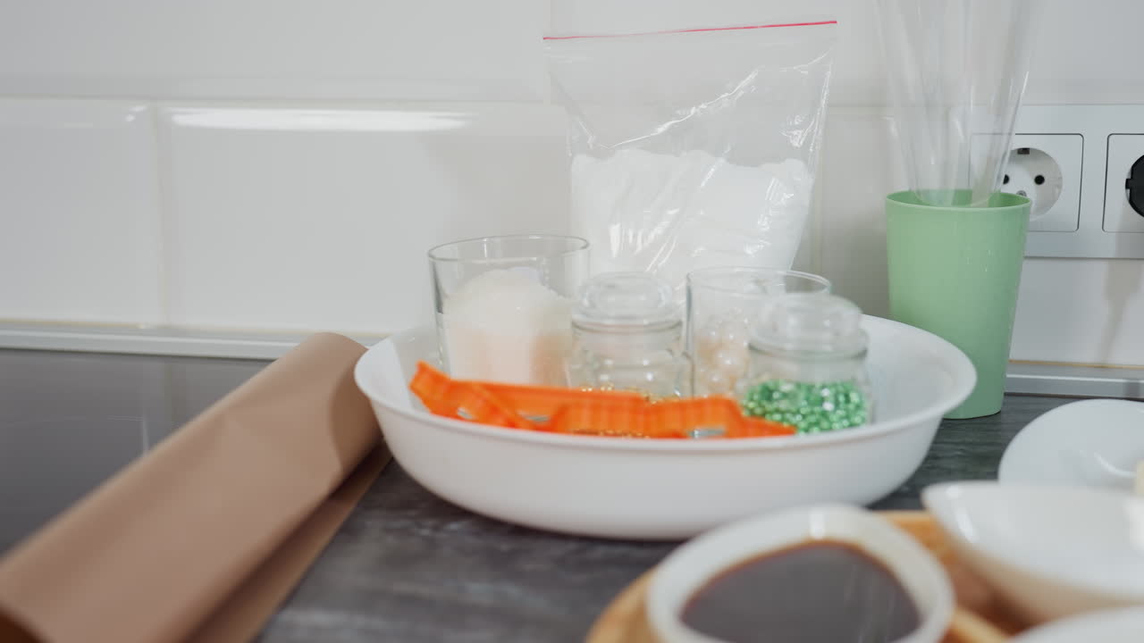 소스, 향신료 및 설탕으로 가득 찬 세라 그, 접시에 버터, 재료, 베이킹 도구 및 주방 용품이 끔하게 배열 된 유리 항아리