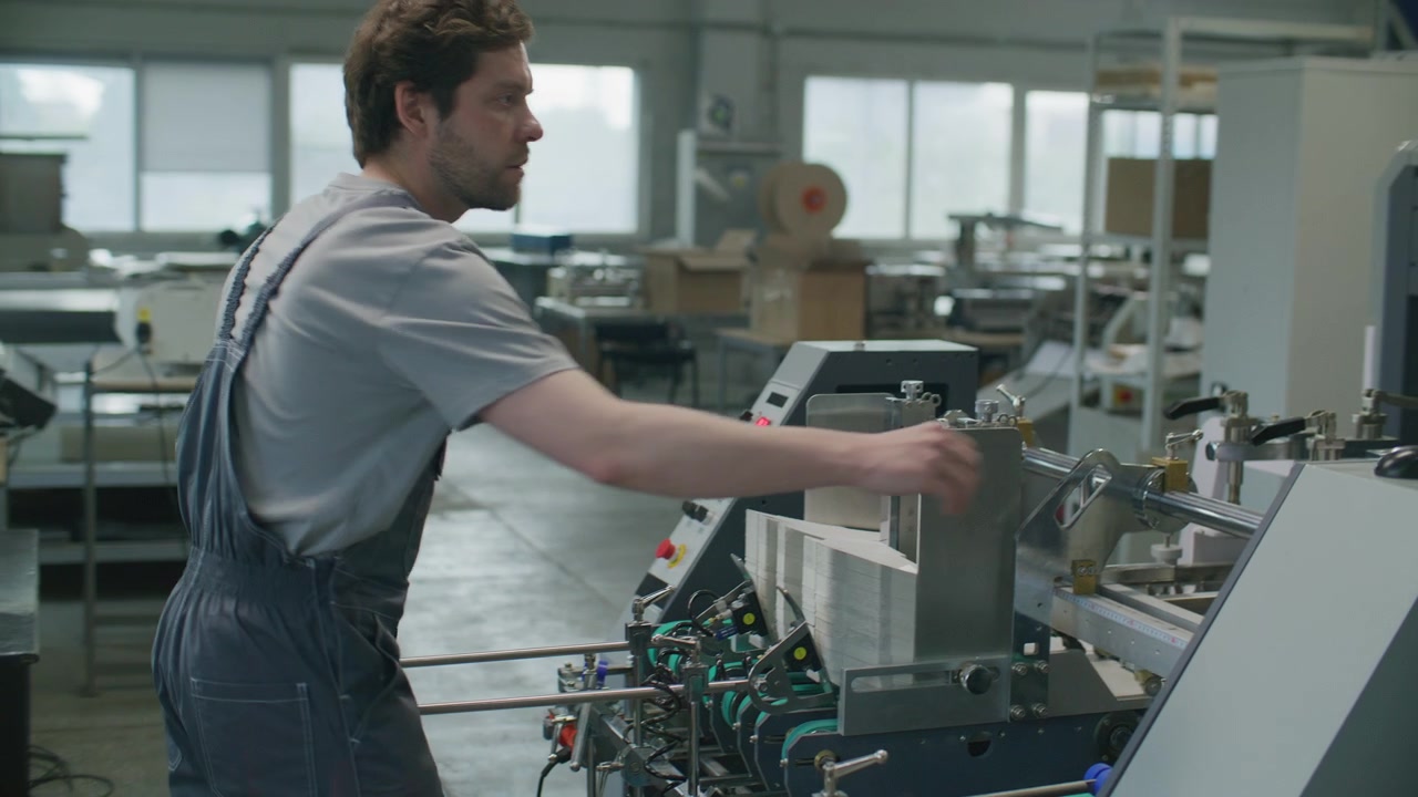 Factory Technician Operating Industrial Printing Machine with Computer