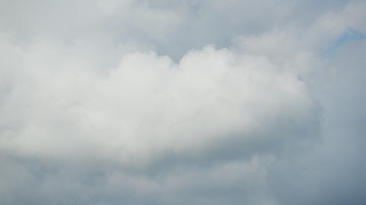 Daytime timelapse of fluffy clouds racing across a blue sky