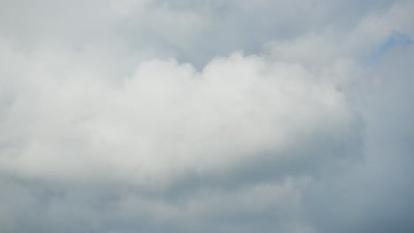 daytime timelapse of fluffy clouds racing across a blue sky