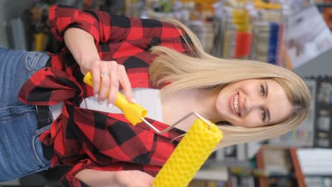 woman holding paint roller in a hardware store