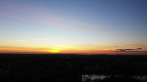 an aerial shot over a suburban neighborhood during a golden sunrise
