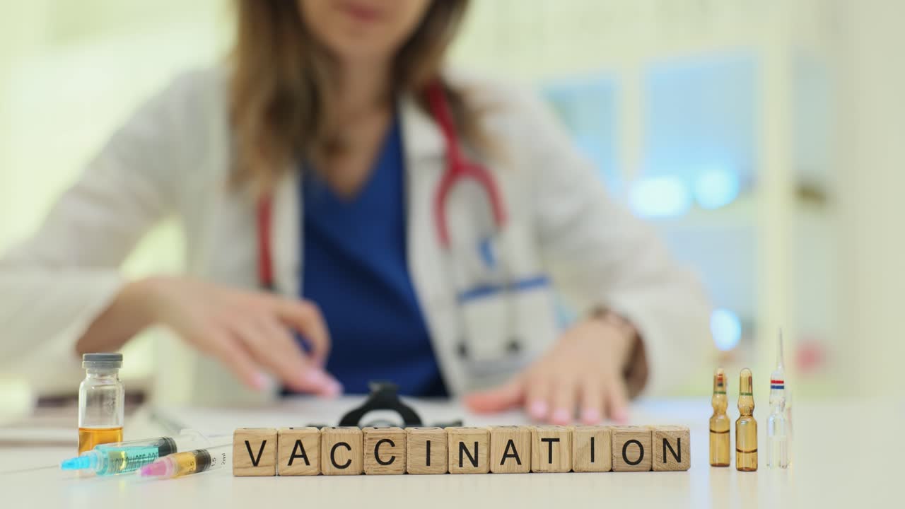 Wooden blocks spell vaccination as doctor prepares shot supplies