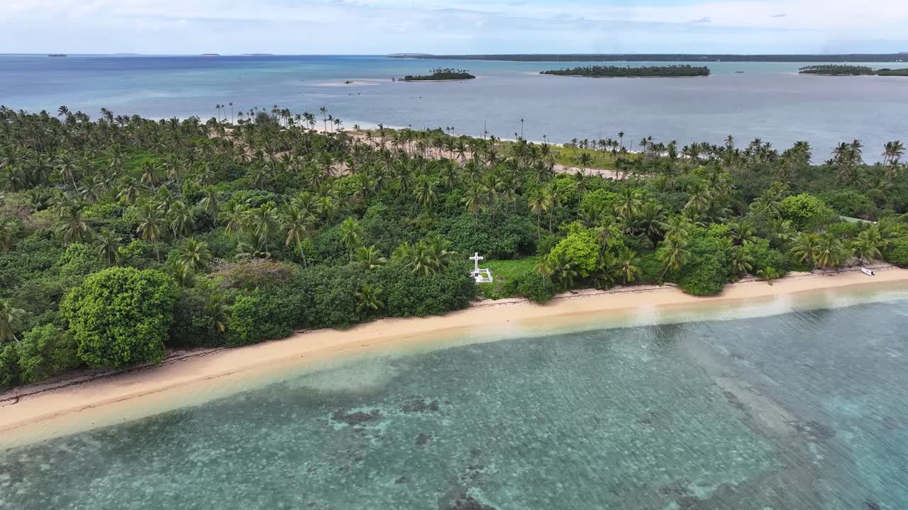 White cross in small paradise island in Pacific Ocean. Christianity, religion, grave, memorial.