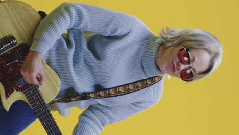 woman playing guitar in studio
