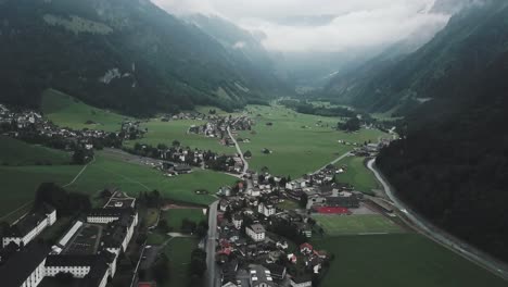 drone aerial slow pan up over small country town of endelberg in switzerland on a cloudy day in between the mountains