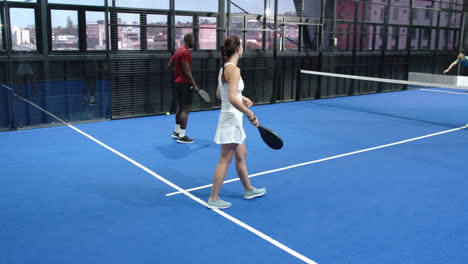 diverse players enjoying intense padel tennis match on vibrant blue indoor court indoors