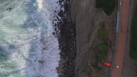 la jolla cove drone vuelo de arriba hacia abajo dividido entre el océano con olas que se estrellan y leones marinos y acantilados rocosos y camino de caminantes en el parque