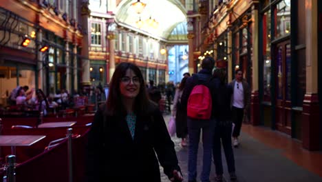 woman walks through busy leadenhall market in london while talking directly to the camera
