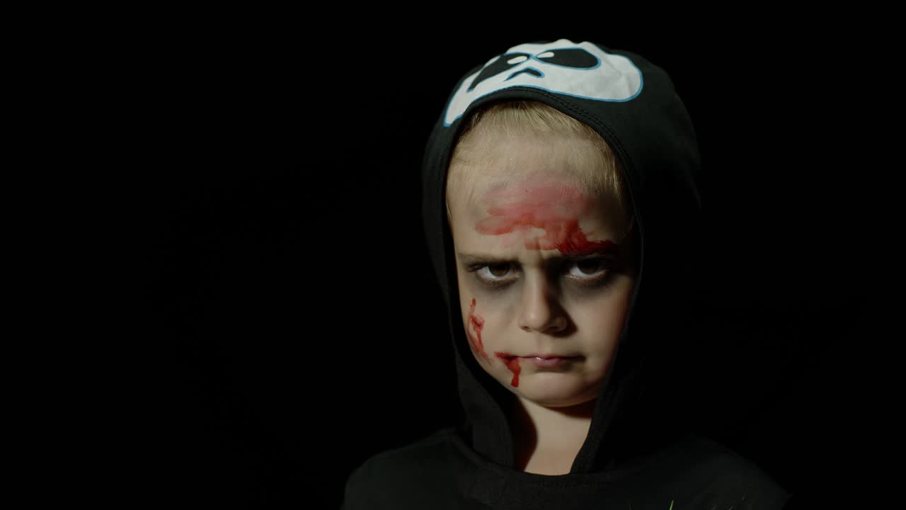 halloween, chica enojada con maquillaje de sangre en la cara. niño vestido como esqueleto aterrador, posando, haciendo caras