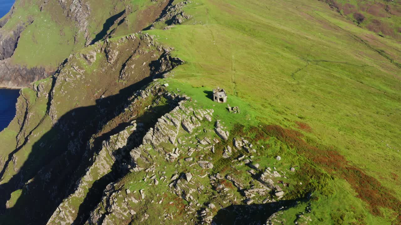 Aerial orbit of The Moytoge Head lookout post with dramatic Atlantic cliffs near Keem Beach, Ireland
