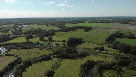 Luftaufnahme-Von-Reggeland-Mit-Dem-Fluss-Regge-In-Twente,-Niederlande,-Der-Sich-Durch-Die-Niederländische-Flache-Landschaft-Mit-Seinen-Ackerflächen-Und-Dem-Ereignislosen-Horizont-Schlängelt