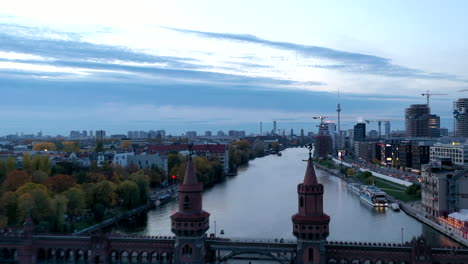 Berlin-Oberbaum-Bridge-at-Sunset-Aerial-Hyperlapse,-Motion-Time-Lapse-of-German-Capital-Cityscape-Tower-Bridge-Establishing-Shot,-Drone-Hyper-Lapse