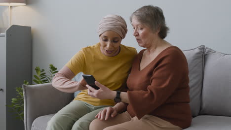 Mujer-árabe-Enseñando-A-Una-Anciana-A-Usar-Un-Teléfono-Inteligente-1