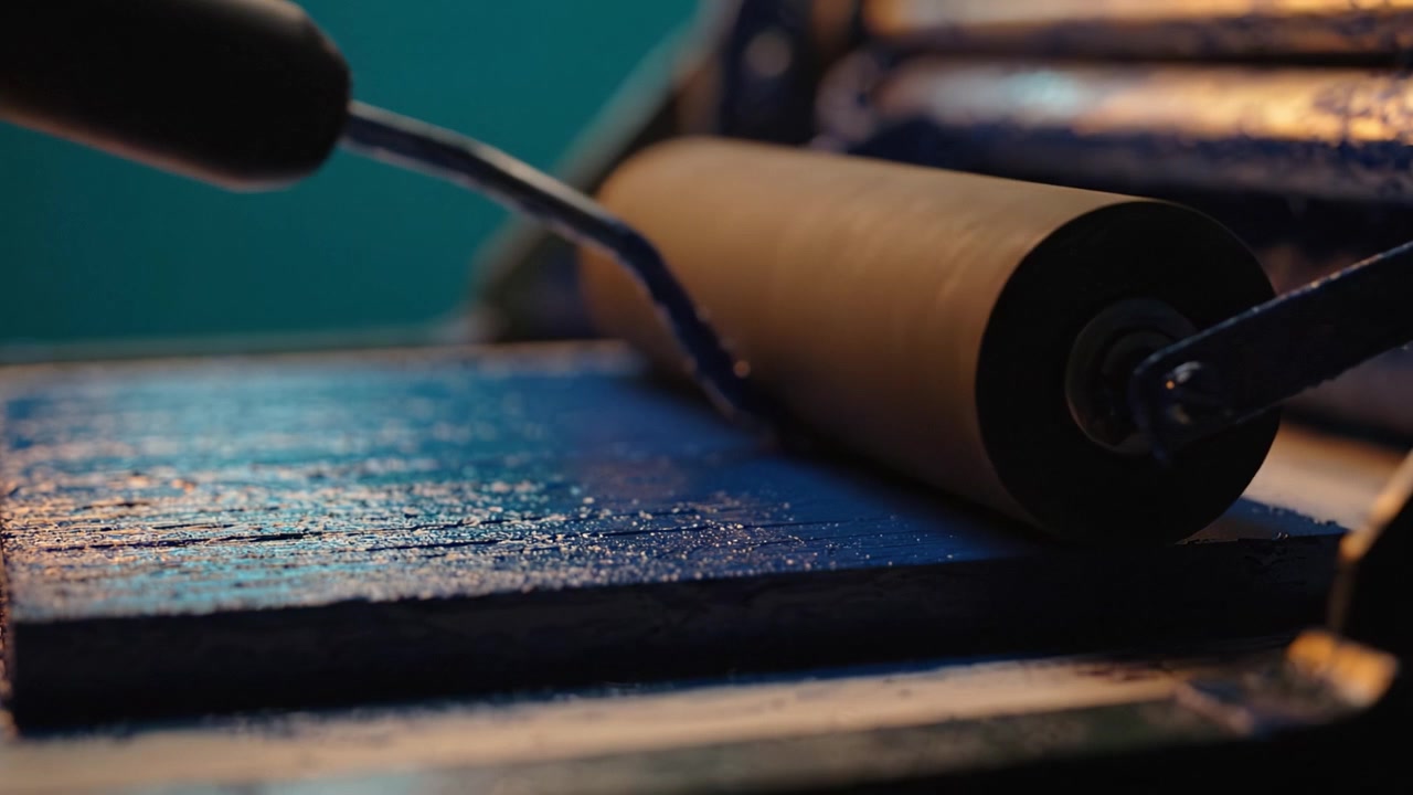 A Close-Up View of Ink Application on a Smooth Surface Using Rollers and Tools in a Colorful Printmaking Process, Capturing Artistic Techniques and Vibrant Colors