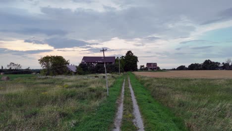 this 4k drone video shows the drone flying low over the road approaching a farm