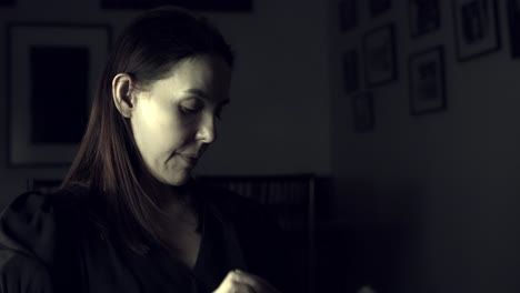 latina woman in a dark room reading a book