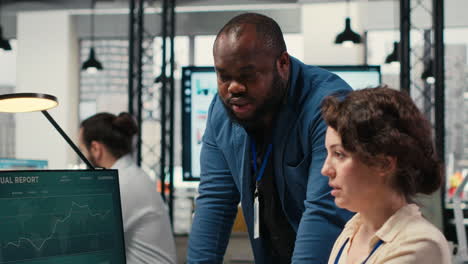 vertical video diverse office coworkers reviewing monthly data graphs to create reports