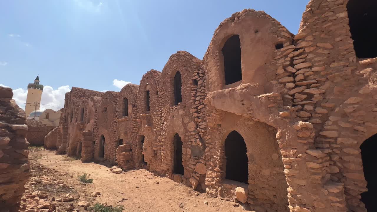 Ksar Hadada granary ruins with mosque in background in Tunisia