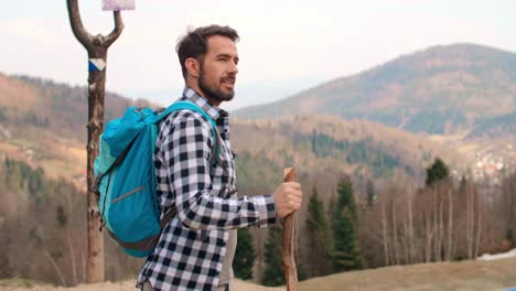 hombre con mochila y bastón caminando en el bosque/bielsko biala/polonia