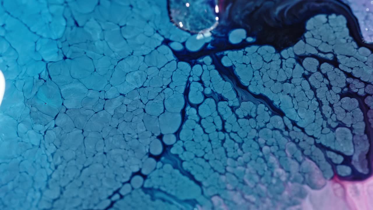 Primo piano astratto di inchiostro blu che si disperde nell'acqua, creando un motivo strutturato.