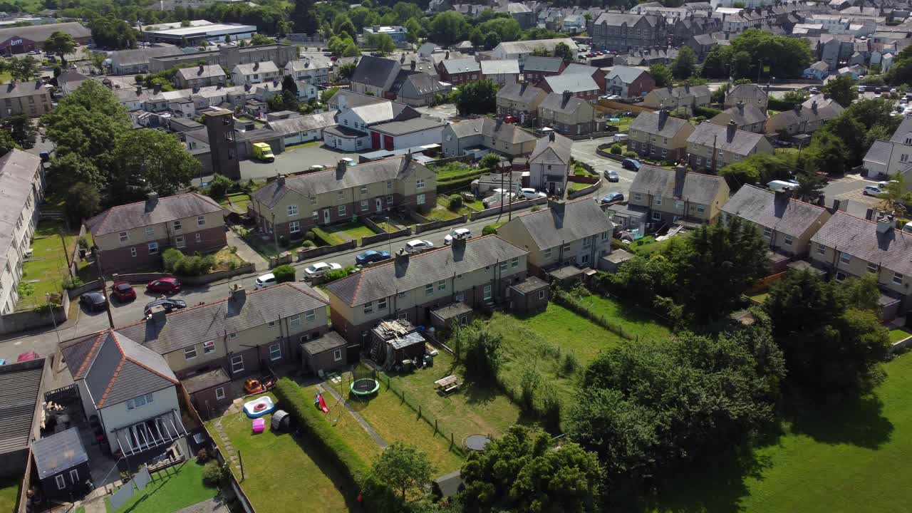 Welsh Llangefni village aerial view looking down over sunny small town homes rooftops and idyllic gardens