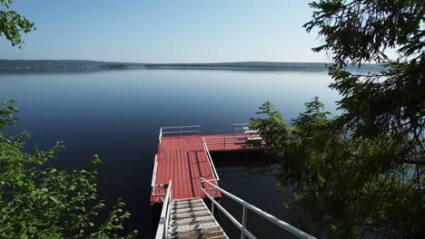 red wooden pier on a calm lake