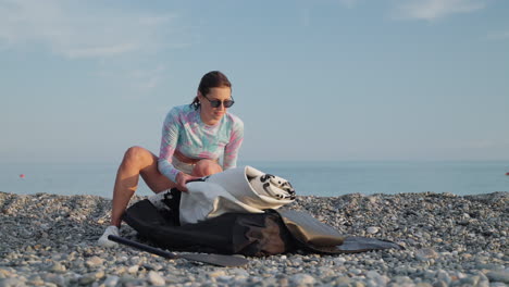 woman preparing a paddleboard on a beach