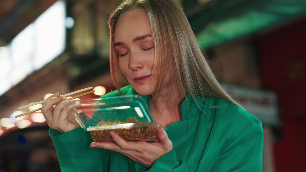 Kvinne som spiser nudler om natten