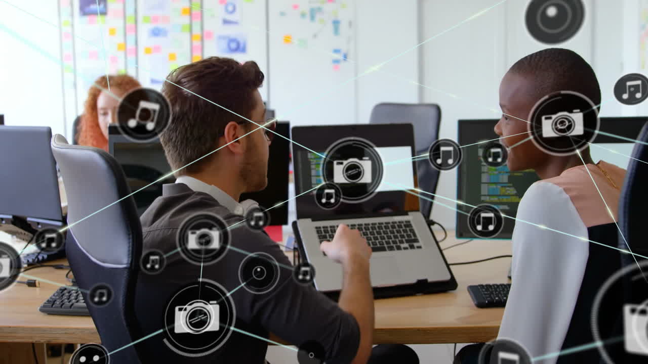Animation of network of connections with icons over diverse colleagues talking in office