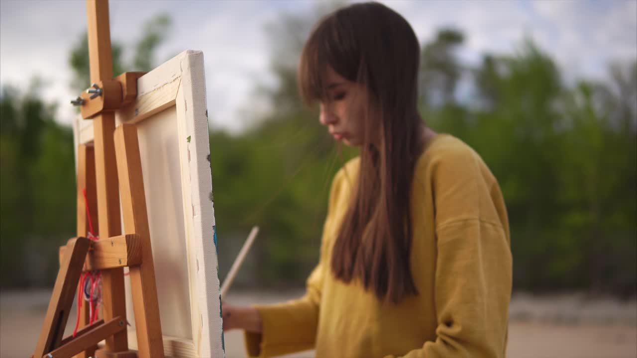 야외에서 그림을 그리는 젊은 예술가