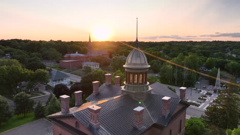 Stillwater-historic-courthouse-with-St-Mary's-church-in-back,-sunset-aerial-view