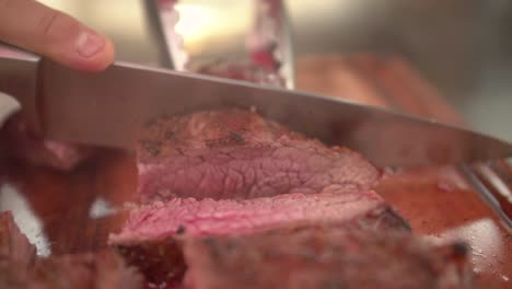 Chef-cutting-juicy-medium-rare-flank-beef,-slow-motion