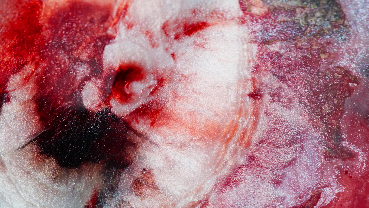 Expanding wave of thick red ink with glitter. Macro view