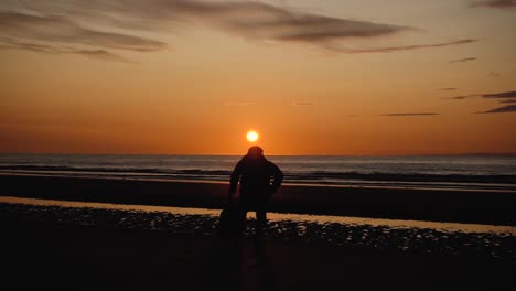 Mann-Läuft-Mit-Gitarre-Im-Hinteren-Sandstrand-Bei-Sonnenuntergang-6