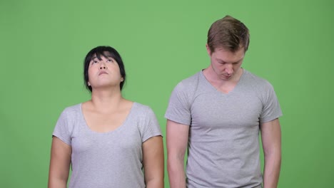young multi-ethnic couple looking at opposite directions together