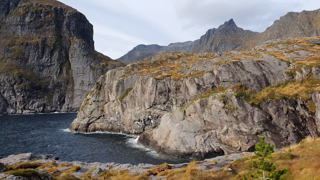 montañas escarpadas y un acantilado rocoso con hierba tundral dorada en noruega